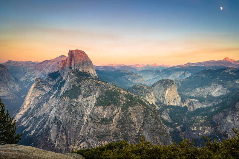 Photo of sunset over Half Dome and the peaks of Yosemite. Autumn.