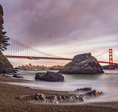 Photo of Golden Gate Bridge and San Francisco skyline from Kirby Cove. Sunset. Winter.