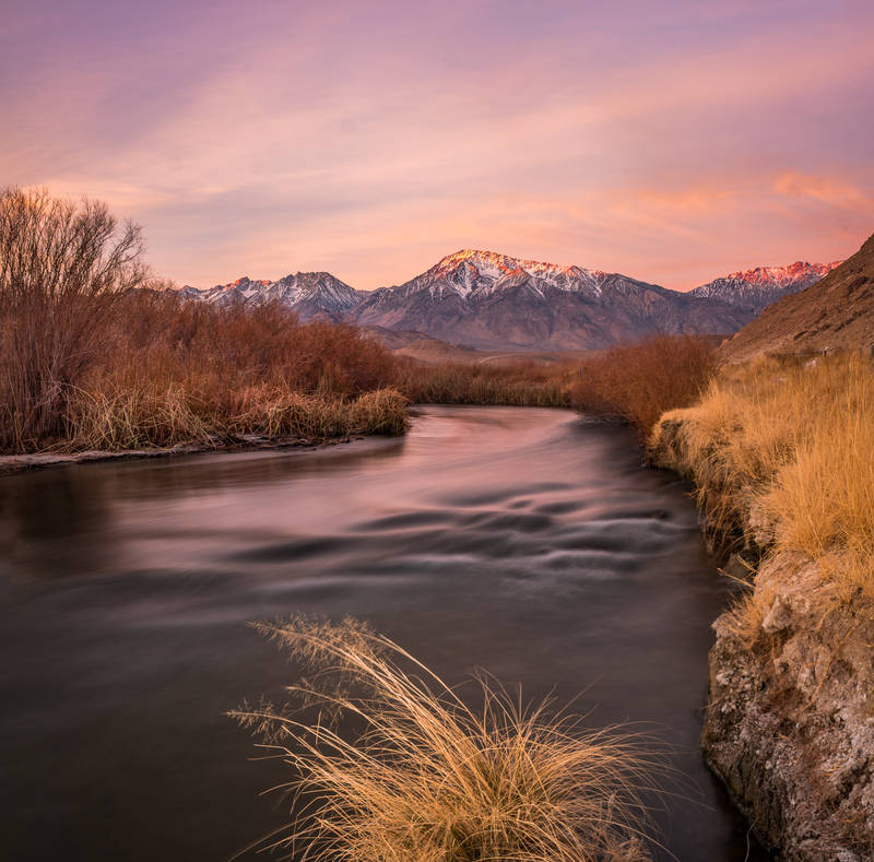 Photo of the Owens River near Bishop, CA and mountains with alpenglow in the background.