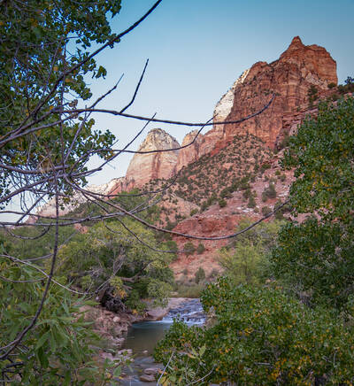 Photo of cascades in Virgin River with a towering cliff behind it. Fall.