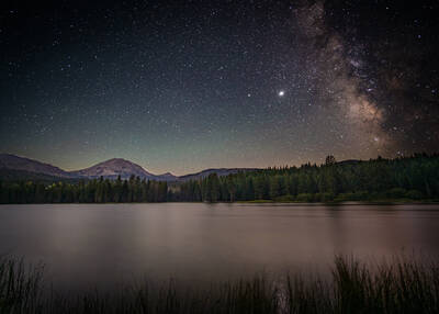 Lassen Peak and Milky Way with a lake in the foreground.