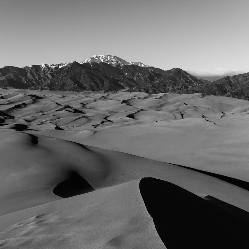 Photo of sand dunes with Monte Cristo mountains in the background.