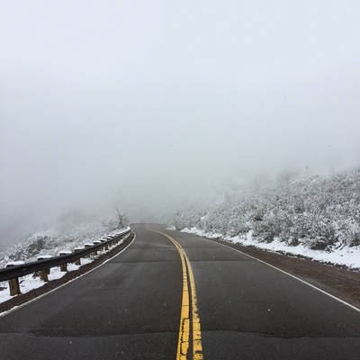 Winding road on Lookout Mountain during snow and fog.